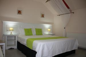 a bedroom with a large white bed with green pillows at Silva House in Deva