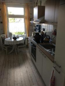 a kitchen with a sink and a table with a window at Ferienwohnung bunte Stadt an der Elde in Grabow