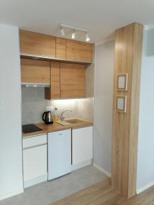 a kitchen with white cabinets and a sink at City Apartments Studio in Zgorzelec