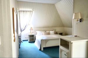 una camera da letto con un letto bianco e una finestra di Parkhotel a Dallgow
