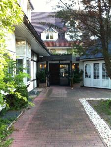 una casa con un passaggio in mattoni che porta alla porta d'ingresso di Parkhotel a Dallgow