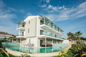 a large white house with a swimming pool at Blue Carpet Luxury Suites in Pefkohori
