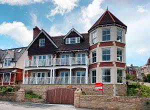 a large house with a balcony on top of a brick wall at The Lookout in Swanage