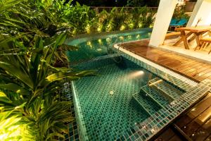 a swimming pool with a table and some plants at The Green Boutique in Panaji