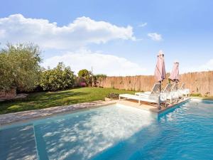 uma piscina com cadeiras e guarda-sóis num quintal em Belvilla by OYO LA TORRE DE SEBASTIA em Fraga