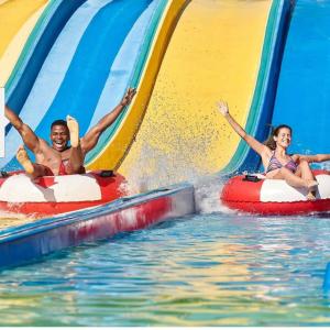 a man and a woman riding down a water slide at Durban Beachfront OceanSeaside Self Catering Apartments in Durban