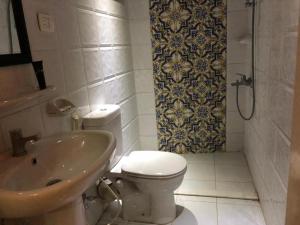 a bathroom with a toilet and a sink and a shower at Tulip Hotel in Cairo