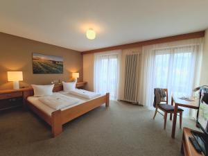 a hotel room with a bed and a desk and a table at Hotel Goldenes Fass in Freudenberg am Main