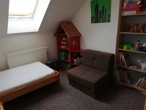 ein Schlafzimmer mit einem Bett, einem Stuhl und einem Bücherregal in der Unterkunft Chalupa in Bučovice