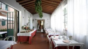 a row of tables in a restaurant with white tables at Hotel Villa Belvedere in San Gimignano
