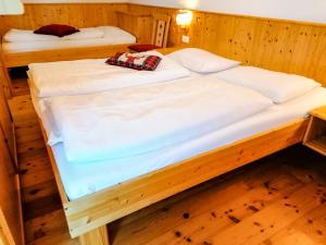 two beds in a room with wooden floors at Appartements Bel Monte - Kärnten Card im Sommer inklusive in Bad Kleinkirchheim