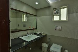 a bathroom with a sink and a toilet and a mirror at The Cliff Resort, Munnar in Munnar
