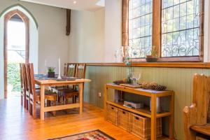 a dining room with a table and chairs and windows at Eastkirk in Corrie