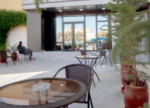 a patio with a table and chairs and a person sitting in at Urban Hotel Nouakchott in Nouakchott