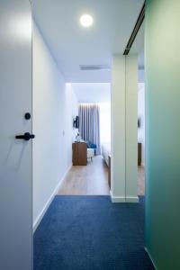 a hallway with a room with a bed and a blue carpet at Hotel Moutados in Vila Nova de Famalicão
