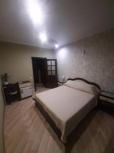 ein Schlafzimmer mit einem großen Bett und Holzboden in der Unterkunft Mini-hotel in Uman