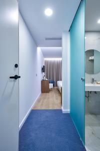 a hallway with a blue carpet and a room at Hotel Moutados in Vila Nova de Famalicão