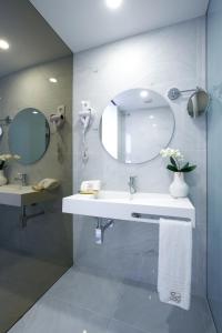 a bathroom with a sink and a mirror at Hotel Moutados in Vila Nova de Famalicão