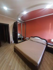 a bedroom with a large bed and a red wall at Mini-hotel in Uman +4 photos