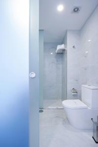 a white bathroom with a toilet and a shower at Hotel Moutados in Vila Nova de Famalicão