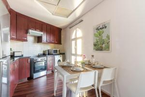 uma cozinha com uma mesa com cadeiras brancas e uma mesa; em The Smart Concierge - Discovery Gardens street 4 em Dubai