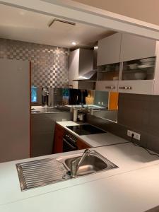 a kitchen with a sink and a counter top at Parkhotel in Dallgow