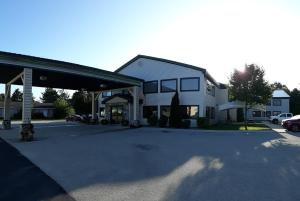 uma casa branca com um parque de estacionamento em frente em Pleasant Moose Lodge em Newberry