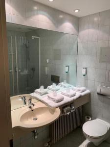 La salle de bains est pourvue d'un lavabo, de toilettes et d'un miroir. dans l'établissement Parkhotel, à Dallgow
