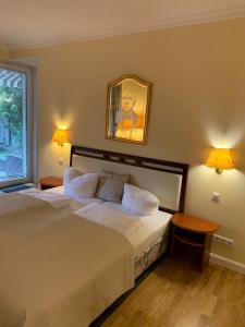 a bedroom with two beds and a picture on the wall at Parkhotel in Dallgow