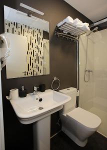 uma casa de banho com um lavatório, um WC e um espelho. em LASARTEROOMS AUTOCHECK-IN em Lasarte