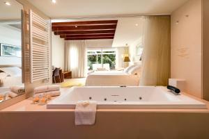 
a bath room with a tub and a sink at Hotel Tancat de Codorniu in Les Cases d'Alcanar
