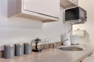 a kitchen counter with a sink and a microwave at Guest Homes - The Foregate in Worcester