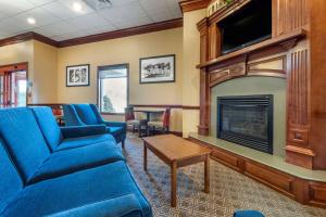 a living room with a blue couch and a fireplace at Quality Inn in Dover