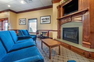 a living room with a blue couch and a fireplace at Quality Inn Dover in Dover