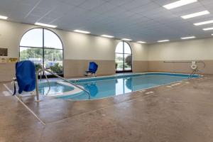 a swimming pool with two chairs in a building at Quality Inn Dover in Dover