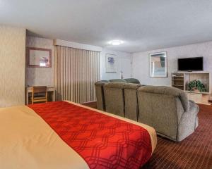 a hotel room with a couch and a television at Econo Lodge St George North - Near Pioneer Park in St. George