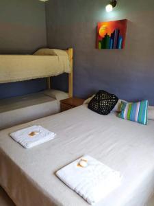 ein Schlafzimmer mit zwei Betten mit Handtüchern darauf in der Unterkunft Casa de campo La Querencia in Villa Cura Brochero + 28 Fotos