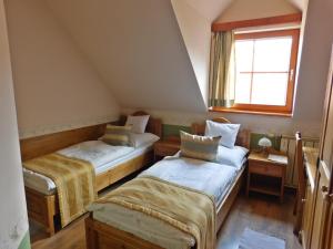 ケルメンドにあるBerki Vendéglő és Hotelのベッド2台と窓が備わる屋根裏部屋です。
