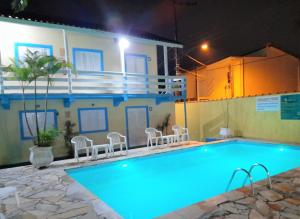 a swimming pool in front of a house at night at Apartamentos Atobá Flats in Juquei