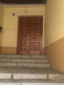 een houten deur op een gebouw met een trap bij AnDiMi Pozo Chico in Toledo