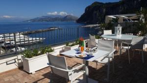 a patio with tables and chairs overlooking the water at Relais Maresca Luxury Small Hotel & Terrace Restaurant in Capri