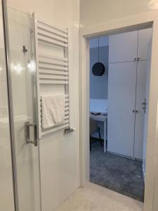 Hotel Coliber في Kłobuck: حمام مع دش وباب زجاجي