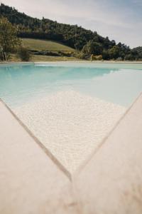 - une vue sur une plage d'eau bleue et d'arbres dans l'établissement Casale di Nicolò, à Urbino