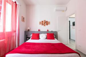 een slaapkamer met een rood en wit bed met rode kussens bij Marconi Dreams in Bologna