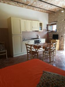 a kitchen with a table and chairs in a room at Guado di Pio- monolocale in Il Guasto