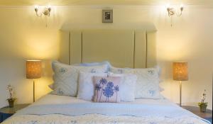 a bed with blue and white pillows and two lamps at Dún Ard in Dungarvan