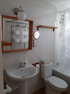 Un baño con lavabo, inodoro y espejo. en La Basilica Apartaments GAM, en Alicante