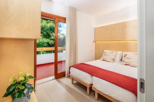 ein Schlafzimmer mit einem Bett und einem Balkon in der Unterkunft Villaggio Los Nidos in Lignano Sabbiadoro