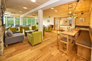 a living room with green chairs and a table at Interest Vitalhotel - Partnerbetrieb von Oberstaufen PLUS in Oberstaufen