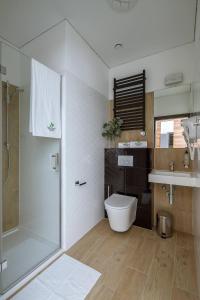 ein Bad mit einer Dusche, einem WC und einem Waschbecken in der Unterkunft Bloom Hotel Airport Okęcie in Raszyn
